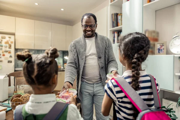 İki esmer kızı okula öğle yemeği kutuları alarak