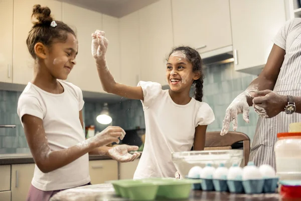 Two siblings feeling funny and excited while cooking together