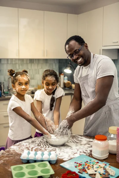Δύο κόρες αίσθημα ενθουσιασμένος μαγειρεύοντας κεκάκια με τον πατέρα — Φωτογραφία Αρχείου