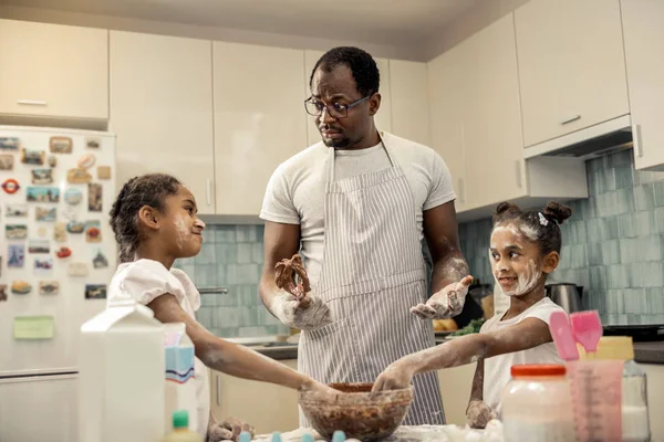 Afrikalı-Amerikalı adam yemek çikolata pasta kızları ile önlük