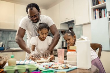 İki kızı babaları hamur yoğurma izlerken ilgili duygu