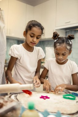 Şirin esmer kardeşler kurabiye pişirme sırasında mutlu hissediyor