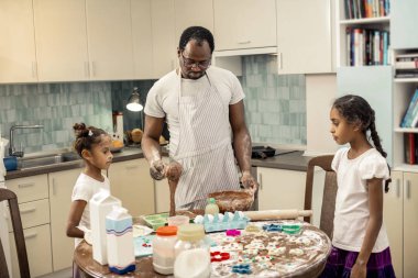 İki kızı kek pişirdiğini neşeli izlerken baba duygu