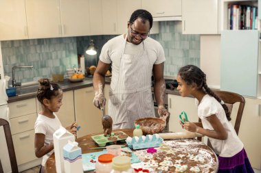 Dostu aile birlikte kek pişirme sırasında gülüyor