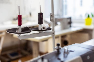 Different needles and cottons being fixed in a big sewing machine