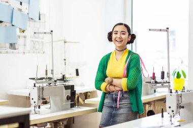 Genç esmer Asyalı Tasarımcısı'nda mutlu gülümseyen bir yeşil hırka