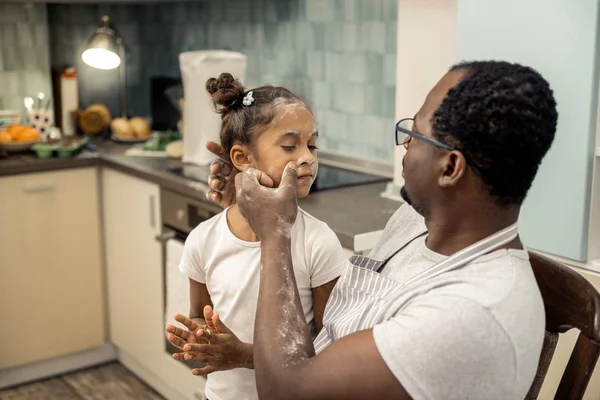 Loving caring father cleaning face of his beautiful girl