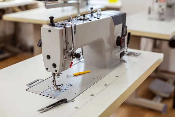 Máquina de coser grande que se utiliza en un proceso de fabricación de nuevos vestidos — Foto de Stock