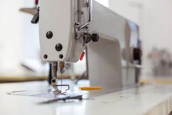 Needle and cotton being used in a big sewing machine in a fashion studio — Stock Photo, Image