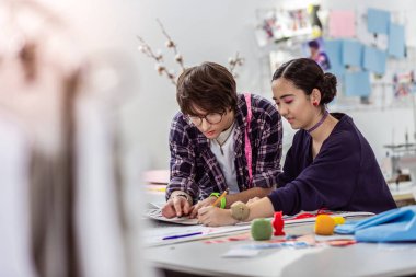 İki genç trendy Asya tasarımcıların yeni bir koleksiyon üzerinde çalışan bir moda