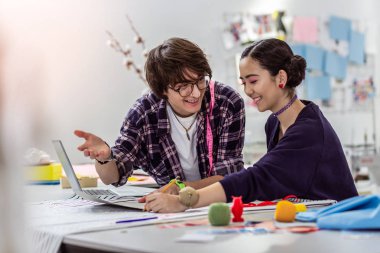 İki genç trendy Asya tasarımcıların mutlu gülümseyen bir moda okulu