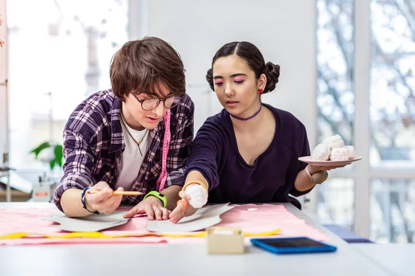 Young beautiful female asian designer advising to her colleague — Stock Photo, Image