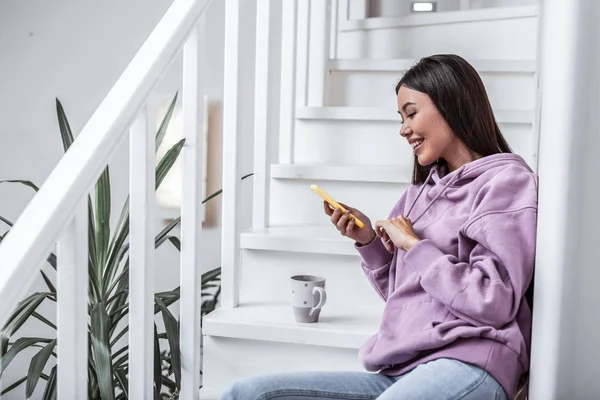 Appealing stylish woman sitting on stars in her cottage house — Stock Photo, Image