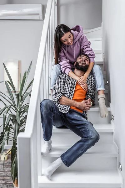 Elegante pareja amorosa sentada en las escaleras mientras descansa en casa — Foto de Stock