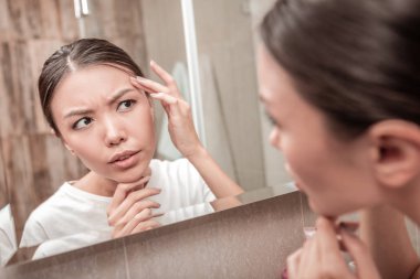 Genç kadın kara gözlü bazı akne derisinin üzerinde görmek