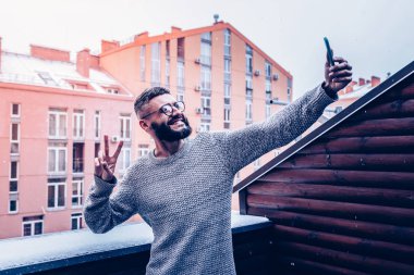 Neşeli genç adam v işaret gösteren sakallı