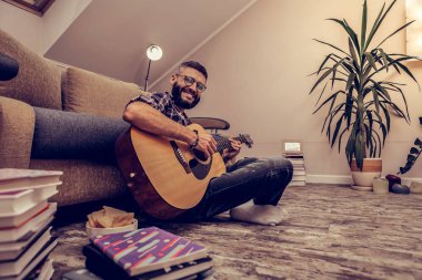 Neşeli mutlu adam gitarı ile oturuyor
