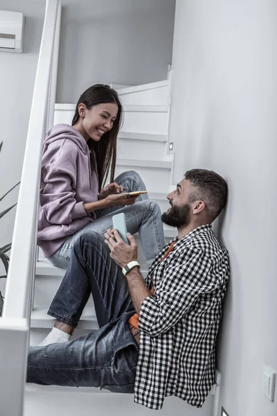 Joven pareja cariñosa riendo mientras se comunica en casa — Foto de Stock