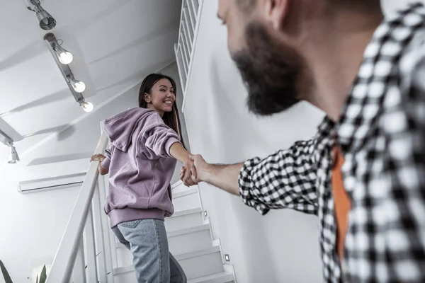 Esposa vistiendo jeans y sudadera con capucha púrpura de la mano del marido — Foto de Stock