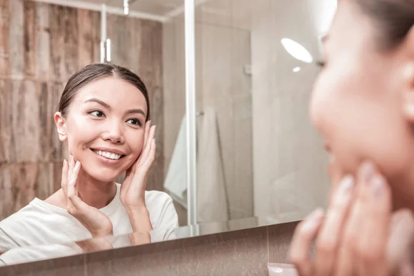 Vackra glada kvinna leende medan du tittar i spegeln — Stockfoto