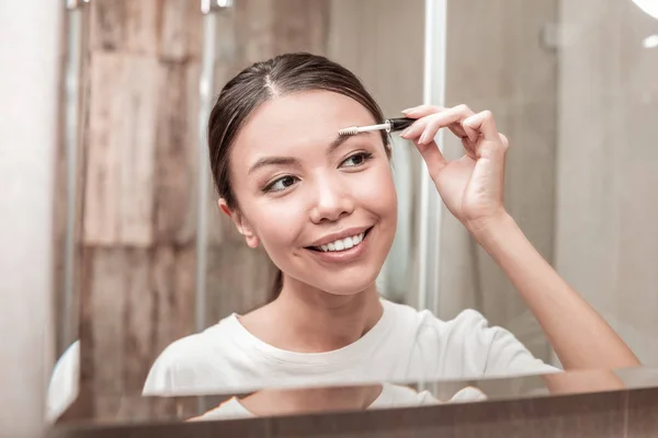 Mujer de negocios de cabello oscuro usando rímel de gel para cejas —  Fotos de Stock