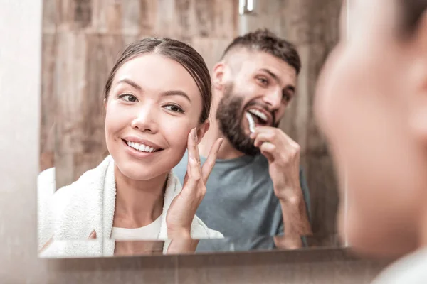 Young loving couple standing in front of mirror together — Stock Photo, Image