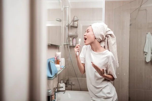Восхищенная позитивной женщиной, поющей в ванной — стоковое фото