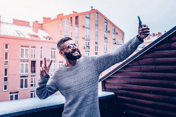 Cheerful bearded young man showing v sign — Stock Photo, Image