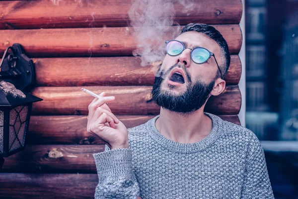 Serious handsome man breathing out cigarette fume — Stock Photo, Image