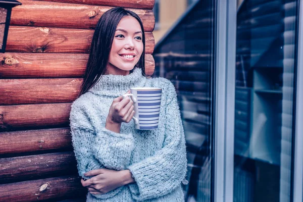 Positiv ung kvinna håller en mugg med kaffe — Stockfoto