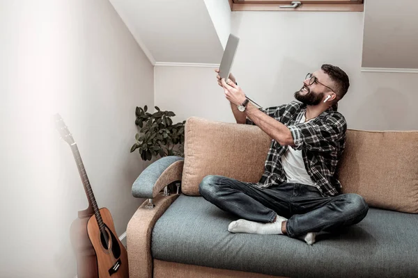 Trevliga glada mannen håller en laptop i hans händer — Stockfoto