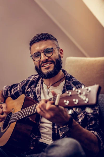 Glad trevlig man som njuter av att spela gitarr — Stockfoto