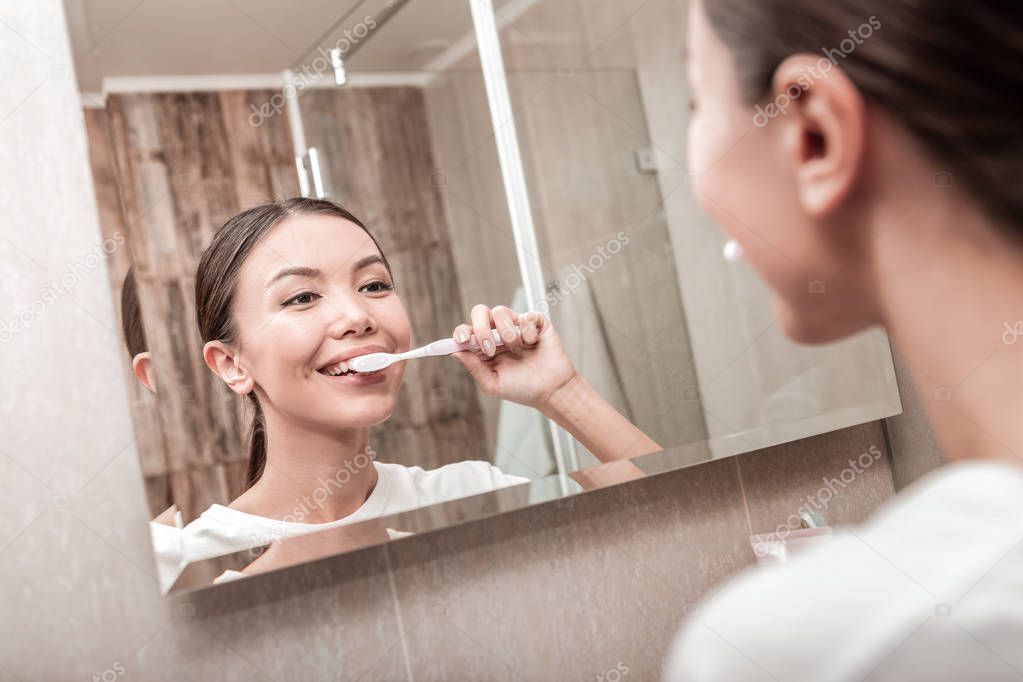 Young businesswoman brushing her teeth in the morning