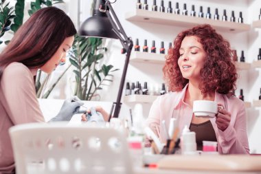 Bir fincan kahve ile oturan neşeli güzel kadın