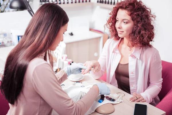 Nette junge Frau gibt dem Nagelmeister die Hand — Stockfoto