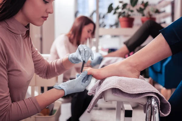 Ernstige mooie vrouw kijken naar haar klanten voet — Stockfoto