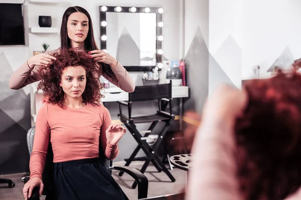 Nice young woman looking at her mirror reflection — Stock Photo, Image