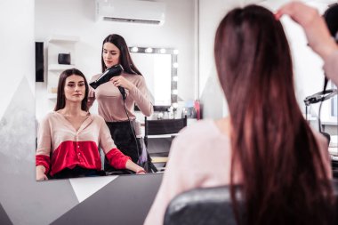 Güzel genç kadın onun saç kurutulmuş olması