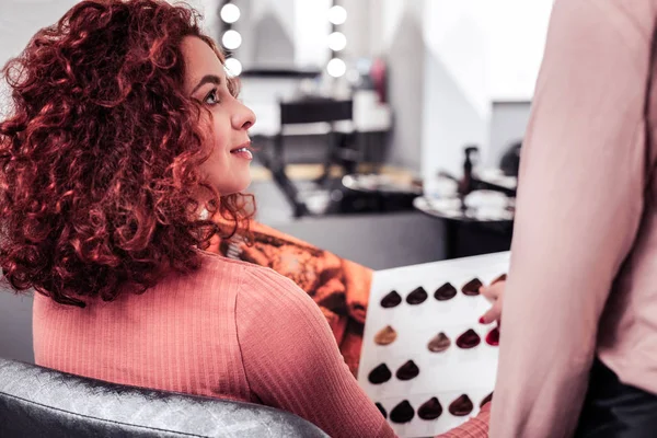 Schöne rothaarige Frau hört ihrem Friseur zu — Stockfoto