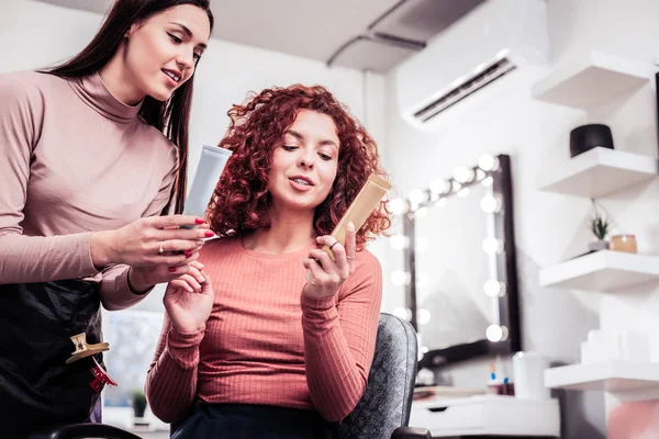 Alegre mujer agradable sosteniendo una botella con loción — Foto de Stock