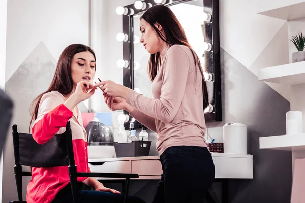 Mujer joven agradable elegir el color del lápiz —  Fotos de Stock