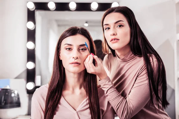 Nice young woman correcting the shape of eyebrows — Stock Photo, Image