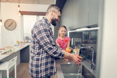 Uzun boylu sakallı yakışıklı kahvaltıdan önce sebze yıkama gözlük