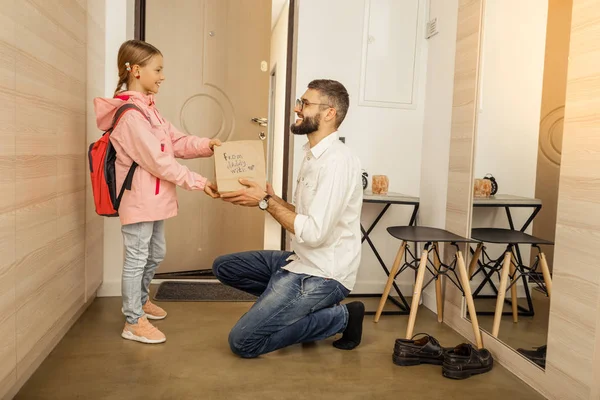 Grand père barbu aux cheveux bruns donnant un cadeau à sa fille — Photo