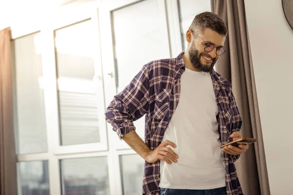 Tall bearded dark-haired man in a checkered shirt feeling good — Stock Photo, Image