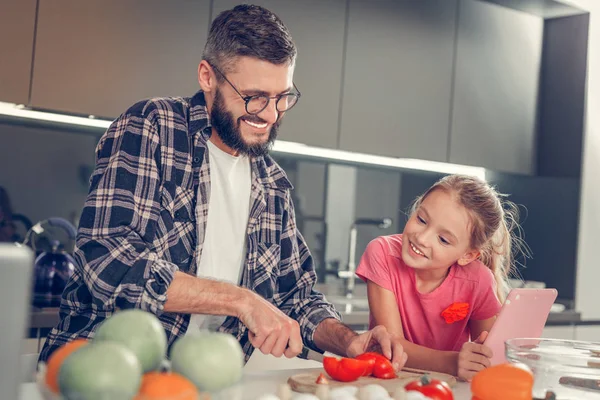 Carino dai capelli lunghi ragazza con un tablet guardando suo padre — Foto Stock