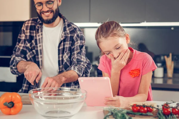 笑って彼女の手でタブレットでかわいい長い髪の少女 — ストック写真