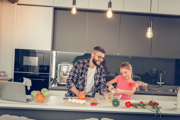 Meisje met lang haar en haar bebaarde vader op zoek verheugd — Stockfoto