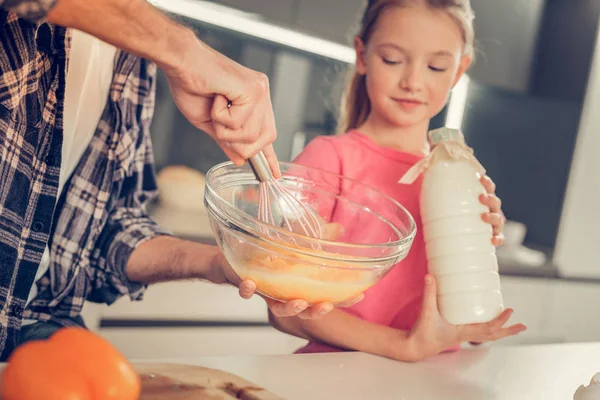 Süßes blondes Mädchen in rosa T-Shirt mit einer Flasche Milch in der Hand — Stockfoto