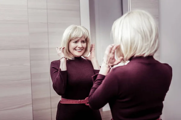 Emotional blonda femeie atingând părul ei artificial — Fotografie, imagine de stoc